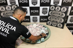 Policial civil organizandosobre uma mesa material apreendido