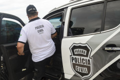 Policial civil entrando em viatura