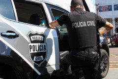 Policial civil entrando em viatura 