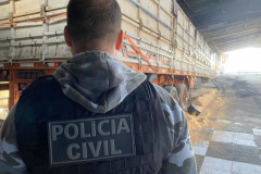 Policial civil de costas, observando caminhão