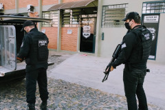Policial retira preso de veículo enquanto outro empunha arma