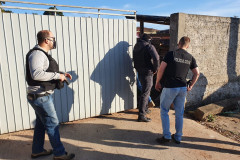 Policiais civis na calçada, acessando local