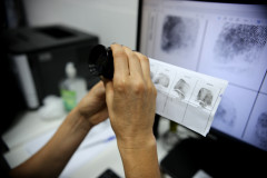 Policial analisa impressões digitais