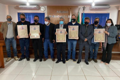 Homenageados e envolvidos no evento posando para foto e exibindo certificados