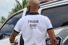 Policial civil de costas, entrando em viatura