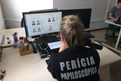 Policial civil analisando imagens em tela de computador