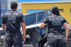 Dois policiais de costas entrando em viatura