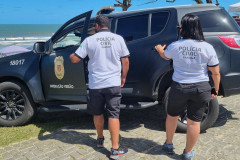 Dois policiais civis entrando em viatura