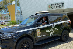 Policial civil saindo com viatura em frente à delegacia cidadã