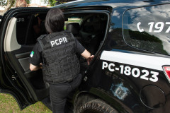 Policial civil entrando em viatura