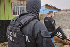 Dois policiais de costas no momento da operação