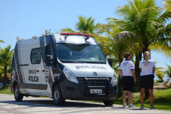 Duas policiais civis ao lado da van estacionada no litoral