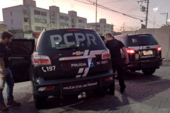 Dois policiais entrando em viatura