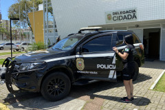 Policiais civis entrando em viatura em frente à delegacia de Matinhos
