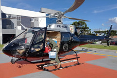 Policial civil saindo de helicóptero com órgãos a serem transplantados