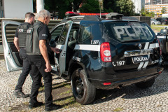 Dois policiais entrando em viatura