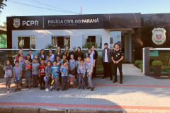 Policiais civis e alunos reunidos em frente à delegacia