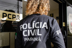 Policial civil de costas entrando em delegacia