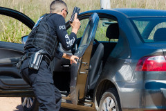 Policial abordando veículo suspeito