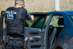 Policial civil aponta arma em direção a veículo suspeito