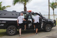 Dois policiais civis entrando em viatura