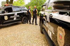 Dois policiais civis entre viaturas