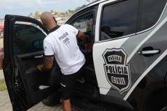 Policial civil entrando em viatura