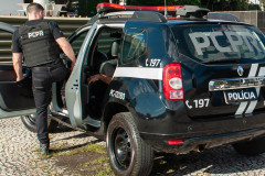 Policial civil entrando em viatura