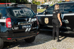 Policial civil entrando em viatura