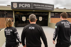 Três policiais civis entrando em delegacia