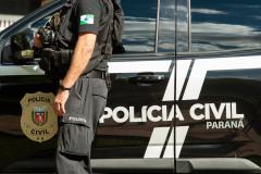 Policial civil ao lado de viatura