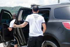 Dois policiais civis entrando em viatura