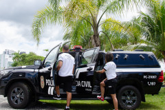 Dois policiais civis entrando em viatura