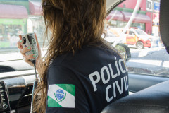 Policial civil ao rádio em viatura