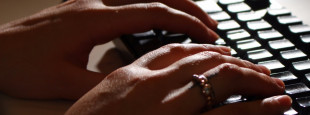 mãos digitando em um teclado de computador