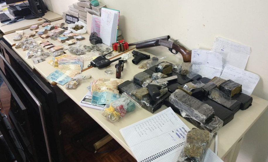 Sbre uma mesa, drogas, armas, dinheiro e produtos apreendidos