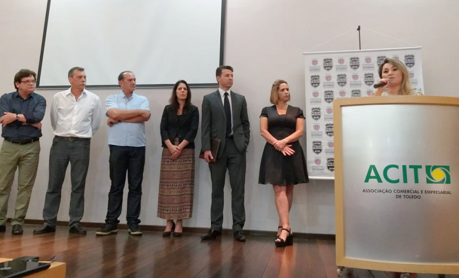 Uma pessoa falando no púlpito e seis prestando atenção