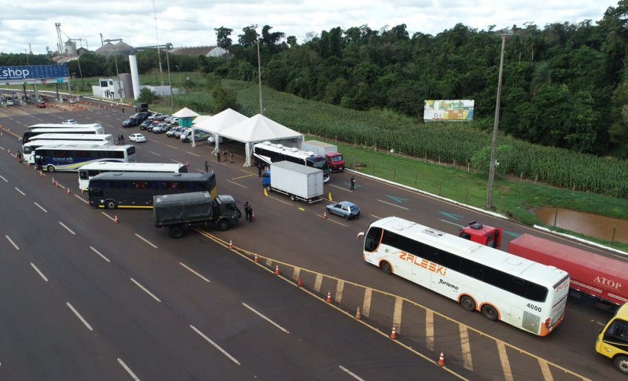 Imagem aérea apresenta movimentação de veículos automotores próximo a uma praça de pedágio no Estado