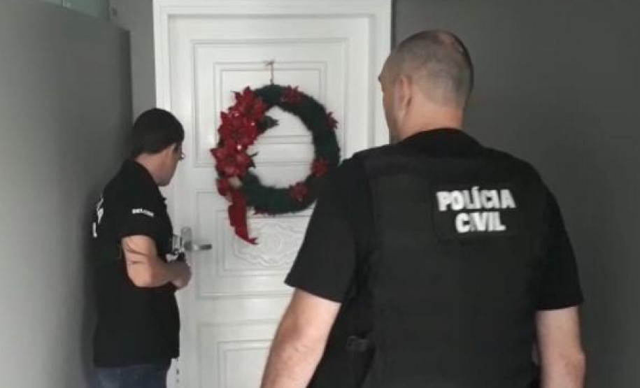 Dois policiais civiscumprindo mandado de prisão.