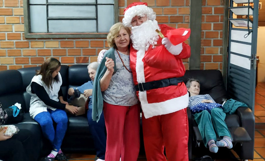 Papai Noel posando para foto com idosa