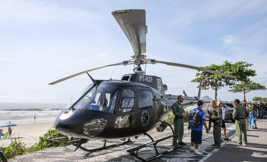 Helicóptero da PCPR e pessoas interagindo com policiais