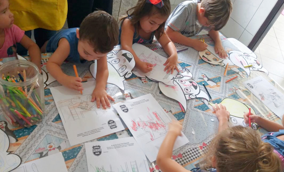 Diversas crianças colorindo desenhos de cães da polícia civil