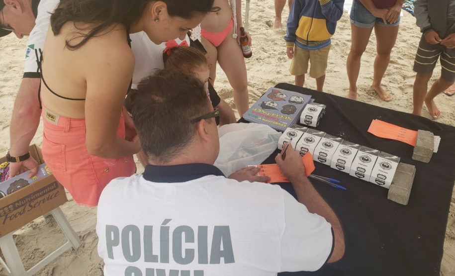 Policial civil preenche nome de criança em pulseirinha
