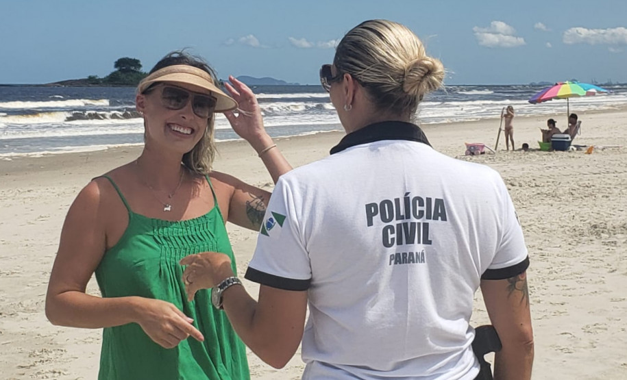 Policial civil orientando uma veranista no litoral
