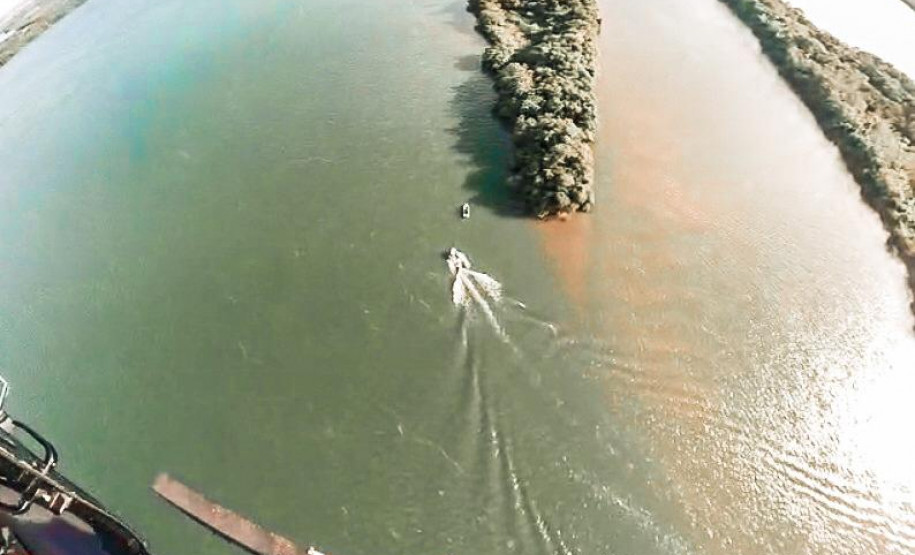 visão de dentro do helicóptero da pcpr em operação sobre o rio paraná