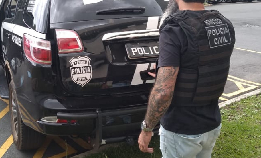 Policial civil abrindo viatura estacionada