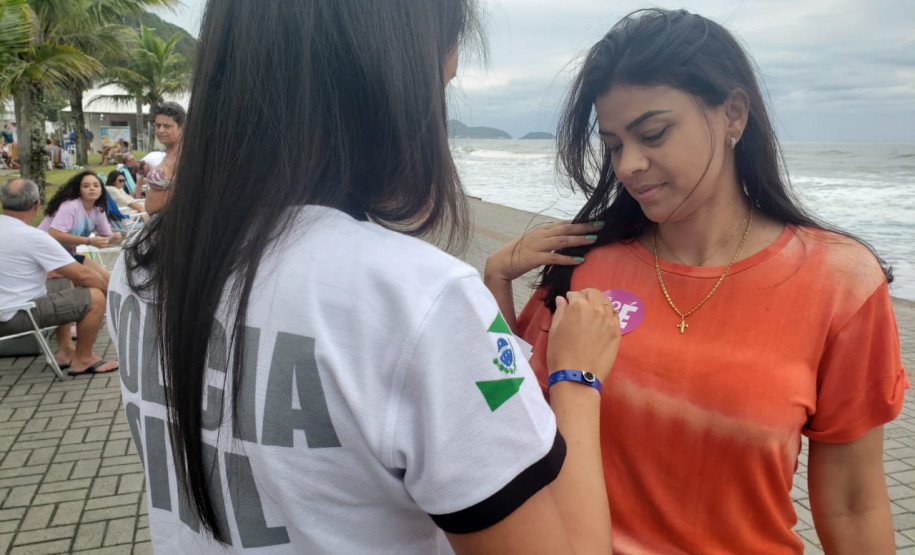 Policial civil colocando o adesivo da campanha