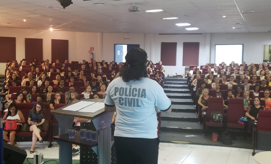 Policial civil ministrando palestra em auditório para educares da rede municipal de Matinhos