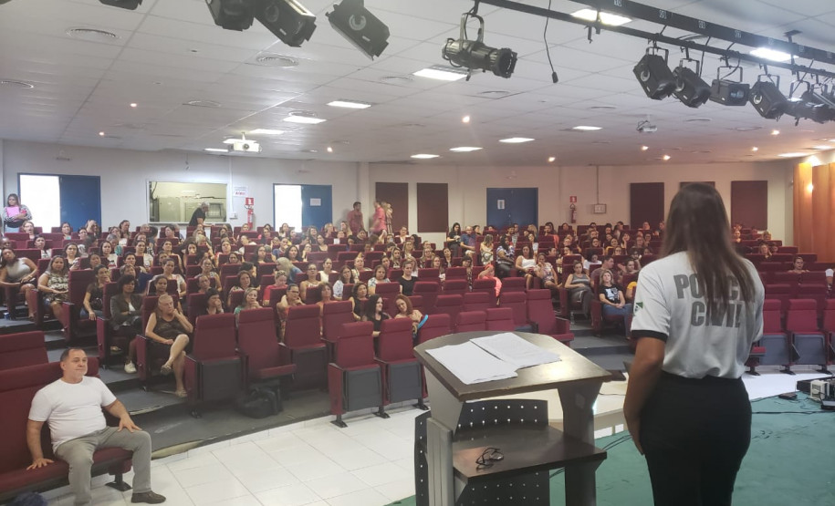 Policial civil ministrando palestra em auditório para educares da rede municipal de Matinhos
