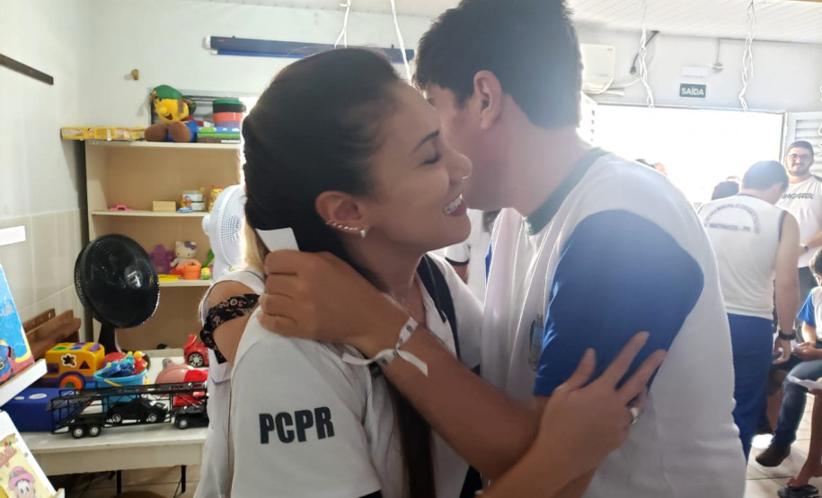 Policial civil recebendo abraço de aluno